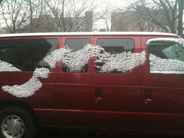 a sweeping stroke of snow on a red van. if only for a moment  